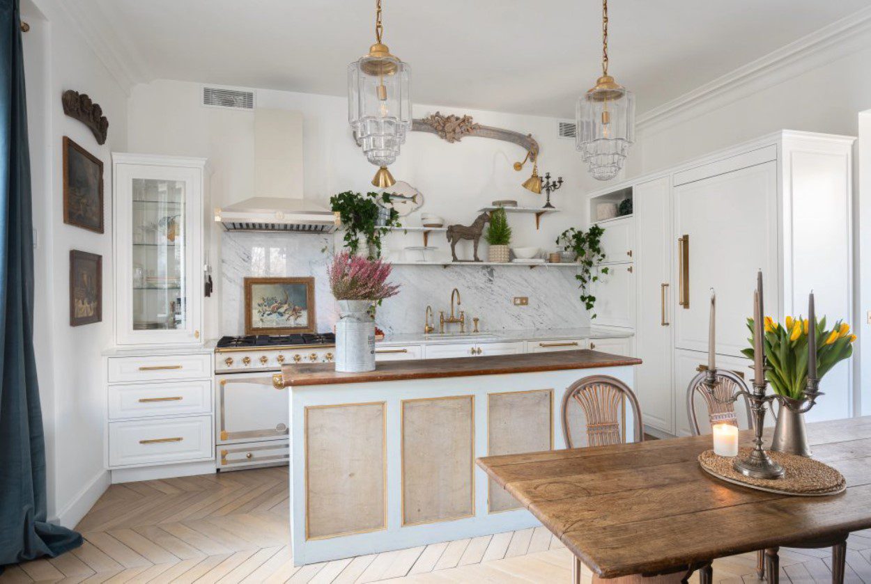 Rue Danton Paris fractional ownership Bright white kitchen with marble backsplash, gold accents, and wooden island.
